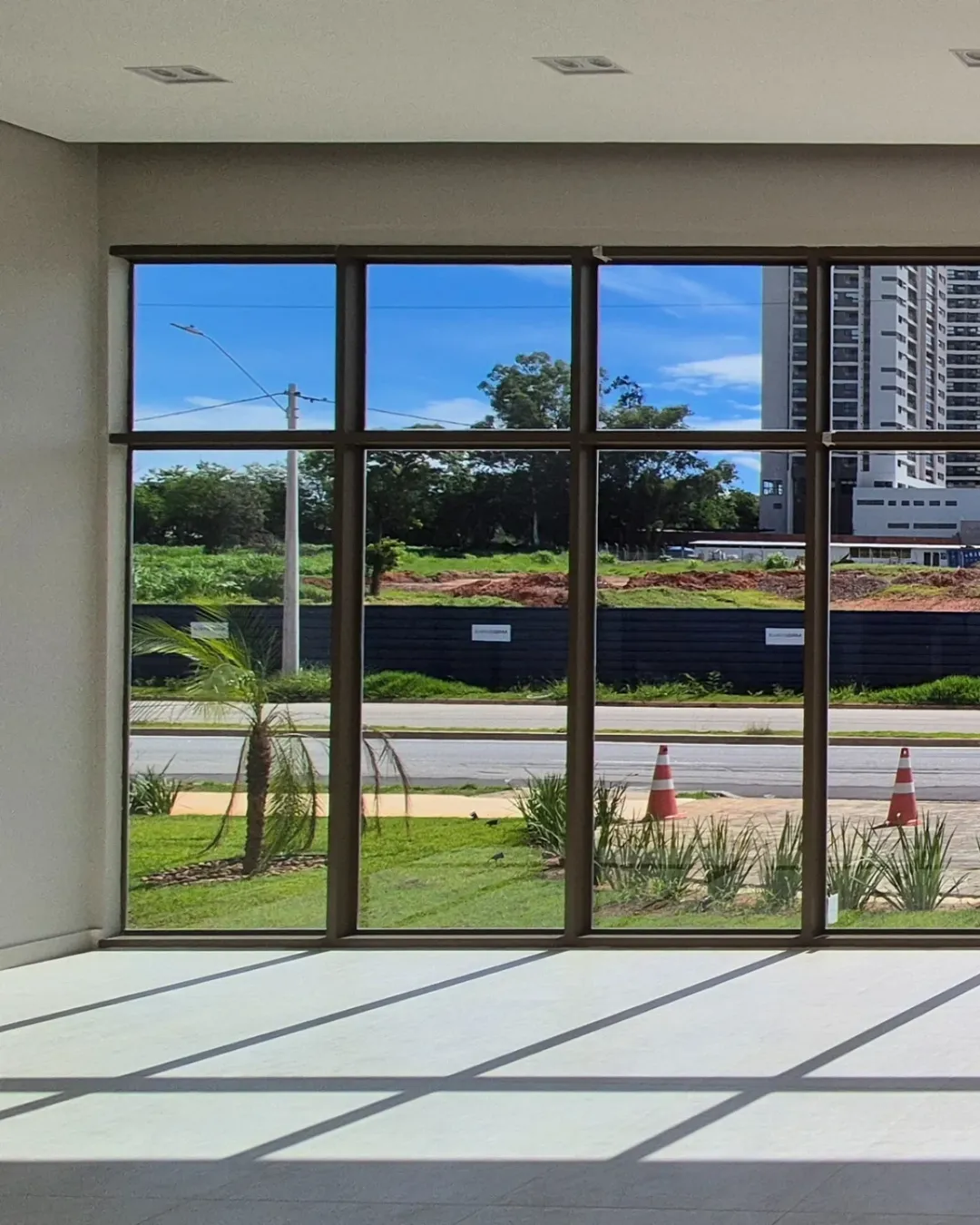 Salão com fachada envidraçada e vista para o exterior