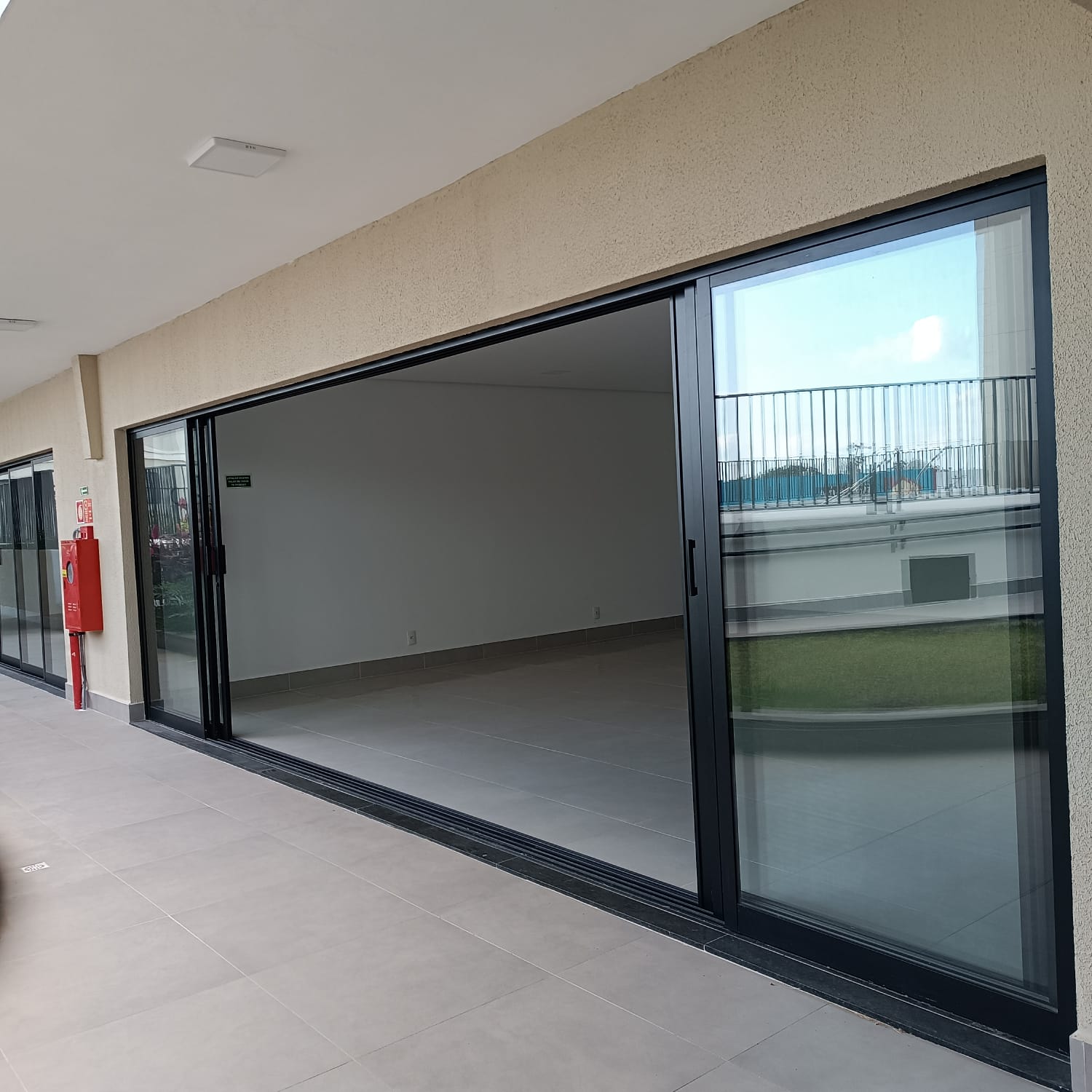 Salão integrado com portas de vidro de grande vão